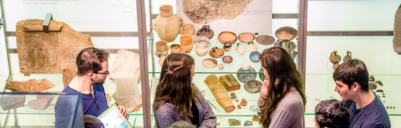 Students looking at artefacts in Manchester Museum