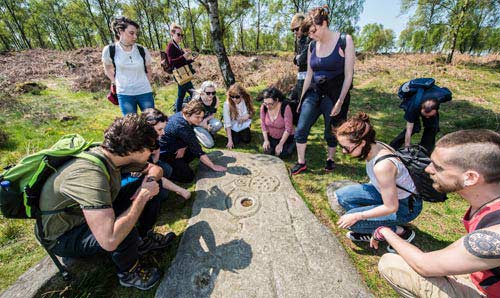 Group of students looking at an ancient engraving